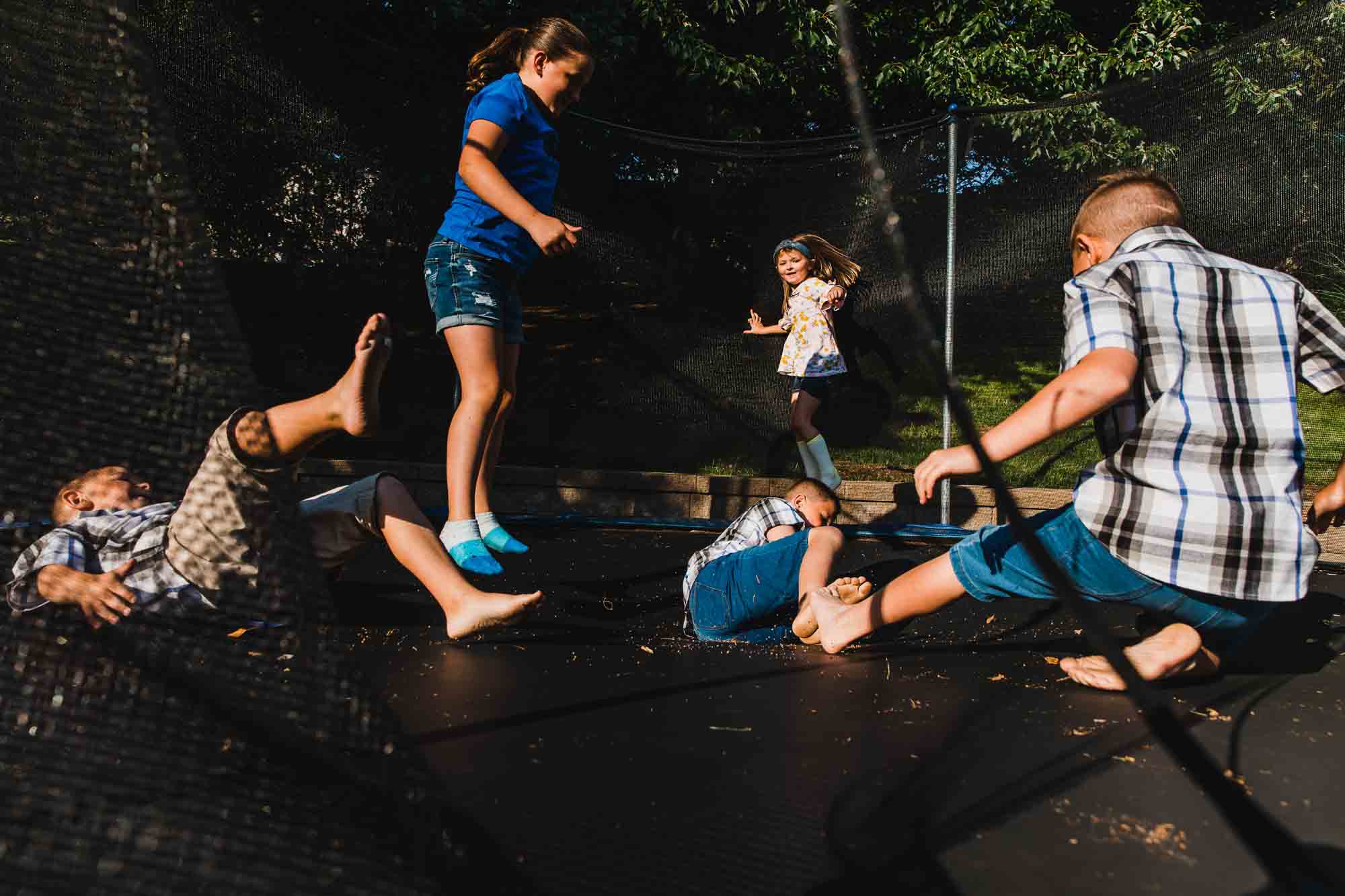 kids playing on a trampoline in the backyard